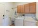 Functional laundry room equipped with modern washer, dryer, sink, and ample cabinet space at 19615 N Sunburst Way, Surprise, AZ 85374