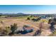 Expansive land with a charming home, highlighting development potential against a backdrop of distant mountains and serene skies at 20521 E Germann Rd, Queen Creek, AZ 85142