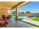 Resort-style backyard featuring a pool, patio, lounge chairs, and lush green turf for ultimate relaxation at 20540 N 86Th Ln, Peoria, AZ 85382