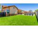 Spacious backyard with a luxurious pool, lounge chairs, and lush artificial turf at 20540 N 86Th Ln, Peoria, AZ 85382