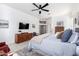 Well-lit bedroom with a ceiling fan, media cabinet, and neutral decor accents at 20540 N 86Th Ln, Peoria, AZ 85382
