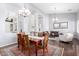 Elegant dining area with hardwood floors and stylish furnishings flowing into an inviting living space at 20540 N 86Th Ln, Peoria, AZ 85382