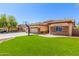 A well-manicured house with grass, stone accents and a driveway leading to attached garage at 20540 N 86Th Ln, Peoria, AZ 85382