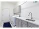 Functional laundry room with modern appliances, stylish cabinets, counter space, and a sink at 20540 N 86Th Ln, Peoria, AZ 85382