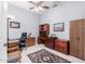 Spacious home office featuring neutral walls, carpet, built-in storage, and a ceiling fan at 20540 N 86Th Ln, Peoria, AZ 85382
