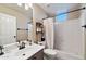 Well-lit bathroom featuring a modern vanity, shower with curtain, and built-in shelves at 20933 N 70Th Dr, Glendale, AZ 85308
