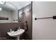 Stylish half bathroom featuring a pedestal sink, elegant lighting, and decorative mirror at 20933 N 70Th Dr, Glendale, AZ 85308
