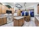 Bright kitchen with wood cabinets, an island, stainless steel appliances, and an adjacent breakfast nook at 20933 N 70Th Dr, Glendale, AZ 85308