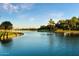 Scenic lake view featuring lush green landscaping, palm trees, and a serene waterfront at 20933 N 70Th Dr, Glendale, AZ 85308