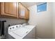 Functional laundry room equipped with a washer, dryer, and overhead cabinetry at 20933 N 70Th Dr, Glendale, AZ 85308