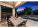 Relaxing covered patio with dining table, grill, and a sparkling pool surrounded by lush landscaping at 20933 N 70Th Dr, Glendale, AZ 85308