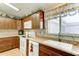 Kitchen with wooden cabinets, sleek appliances including a white dishwasher, and a view from the window at 2101 S Meridian Rd # 99, Apache Junction, AZ 85120
