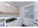 Functional laundry room with washer, dryer, storage cabinets, and screened exit door at 2101 S Meridian Rd # 99, Apache Junction, AZ 85120