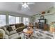 Inviting living room boasts a plush sectional sofa, decorative fireplace, and ample natural light from expansive windows at 2101 S Meridian Rd # 99, Apache Junction, AZ 85120