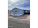 Charming blue mobile home with awning, carport and rock landscaping at 2121 N Center St # 141, Mesa, AZ 85201