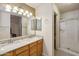 Bathroom featuring granite countertops, dual sinks, and a glass-enclosed shower at 2123 E Catclaw St, Gilbert, AZ 85296