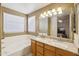 Bright bathroom boasts double sinks, granite counters, and a luxurious soaking tub at 2123 E Catclaw St, Gilbert, AZ 85296