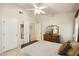 Neutral bedroom with ceiling fan, mounted TV, and classic wood dresser and furnishings at 2123 E Catclaw St, Gilbert, AZ 85296