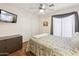 Comfortable bedroom features wood floors, a ceiling fan, and a mounted television at 2123 E Catclaw St, Gilbert, AZ 85296