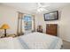 Bedroom with ceiling fan, and mounted TV above a wood dresser for storage at 2123 E Catclaw St, Gilbert, AZ 85296