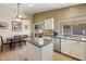 Kitchen with an island, stainless steel dishwasher, and tile flooring, plus a dining area at 2123 E Catclaw St, Gilbert, AZ 85296