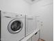 Functional laundry room with washer, dryer, and built-in storage at 2123 E Catclaw St, Gilbert, AZ 85296