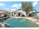 Backyard view of a pool with rock features and a covered patio at 2123 E Catclaw St, Gilbert, AZ 85296