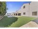 Large backyard with a pool, cabana, manicured turf and neutral stucco home exterior at 2285 E Chandler Heights Rd, Chandler, AZ 85249