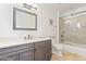 Well-lit bathroom with vanity, framed mirror, and shower with tile surround at 2285 E Chandler Heights Rd, Chandler, AZ 85249