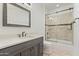 Well-lit bathroom featuring a dark wood vanity and framed glass shower door with tan tiled walls at 2285 E Chandler Heights Rd, Chandler, AZ 85249