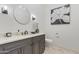 Elegant powder room featuring a round mirror, sconces, and decorative floral art at 2285 E Chandler Heights Rd, Chandler, AZ 85249