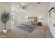 Neutral bedroom with a tufted headboard, ceiling fan, and a leafy ornamental tree at 2285 E Chandler Heights Rd, Chandler, AZ 85249