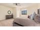 Relaxing bedroom with a dark wood dresser, circle mirror, and plush pillows at 2285 E Chandler Heights Rd, Chandler, AZ 85249