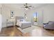 Well-lit bedroom features a padded headboard, ceiling fan, and wood floors at 2285 E Chandler Heights Rd, Chandler, AZ 85249