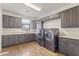 Spacious laundry room with gray cabinetry, a long countertop, and modern appliances at 2285 E Chandler Heights Rd, Chandler, AZ 85249