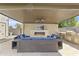 Relax in this cozy outdoor living space complete with a fireplace, TV, and built-in grill at 2285 E Chandler Heights Rd, Chandler, AZ 85249