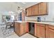 Eat-in kitchen area features wooden cabinetry, modern dishwasher, and lots of storage space at 2455 E Broadway Rd # 13, Mesa, AZ 85204