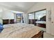 Main bedroom with dark wood furniture, mirrored closet, and sliding glass door to patio at 2455 E Broadway Rd # 13, Mesa, AZ 85204