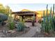 Entertain in this home's backyard featuring an outdoor living space and desert landscaping at 27654 N 125Th Dr, Peoria, AZ 85383