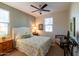 Bedroom with a ceiling fan, bright windows, and a small seating area with a writing desk at 27654 N 125Th Dr, Peoria, AZ 85383