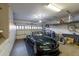 Well-lit garage features epoxy floors, a convertible car, and ample storage space at 27654 N 125Th Dr, Peoria, AZ 85383