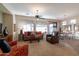 Spacious living room featuring neutral tones, a ceiling fan, and a seamless flow into the dining area at 27654 N 125Th Dr, Peoria, AZ 85383
