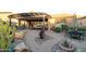 Gorgeous outdoor living space featuring desert landscaping, pergola, and stone walkway at 27654 N 125Th Dr, Peoria, AZ 85383