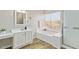 Bright bathroom showcasing a large garden tub under a window and a vanity with a makeup counter at 2916 E Amber Ridge Way, Phoenix, AZ 85048