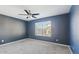 Cozy bedroom with a ceiling fan, gray carpet, and a window that provides natural light at 2916 E Amber Ridge Way, Phoenix, AZ 85048