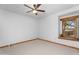 Cozy bedroom featuring carpet floors, ceiling fan, and wooden window frame with a beautiful outdoor view at 29204 N Bryce Trl, Queen Creek, AZ 85144