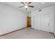 A bright bedroom features carpet floors, a ceiling fan, closet with sliding doors, and wooden door at 29204 N Bryce Trl, Queen Creek, AZ 85144