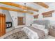 Bedroom featuring a fireplace, a king bed, and exposed wooden beams at 29204 N Bryce Trl, Queen Creek, AZ 85144