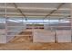 Close up of a horse stall under a metal roof, featuring a dirt floor and partially covered wood framing at 29204 N Bryce Trl, Queen Creek, AZ 85144