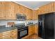 Kitchen showcasing knotty wood cabinetry and modern, black appliances at 29204 N Bryce Trl, Queen Creek, AZ 85144